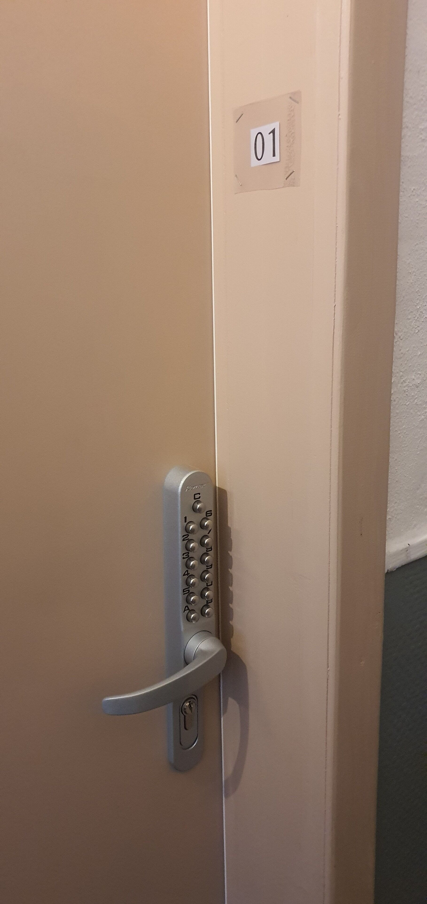 A door with a numeric keypad lock and a keyhole, marked with the number 01.