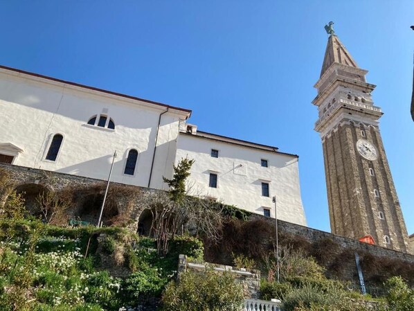 A historic building with a clock tower, arched windows, and a stone wall. - JMJ Nono, charming 1-bedroom holiday house with AC, WiFi in lovely Piran (Piran)