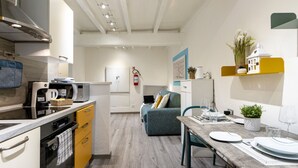 Una cucina moderna con forno a microonde, forno e zona pranzo con tavolo apparecchiato per due.