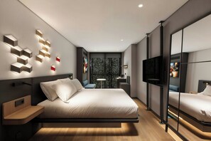 Un dormitorio moderno con cama, mesitas de noche, televisor y un espejo grande.