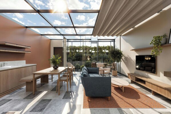 Una cocina moderna con comedor, sofá y televisor.