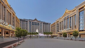 A hotel with a large, symmetrical facade, multiple floors, and a central decorative element. - Four Points By Sheraton Xishuangbanna (Xishuangbanna Dai)