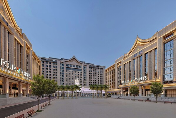 A hotel with a large, symmetrical facade, multiple floors, and a central decorative element. - Four Points By Sheraton Xishuangbanna (Xishuangbanna Dai)