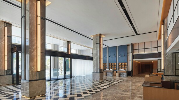 A spacious lobby with a checkered floor, large pillars, and a reception area with seating. - Four Points By Sheraton Xishuangbanna (Xishuangbanna Dai)