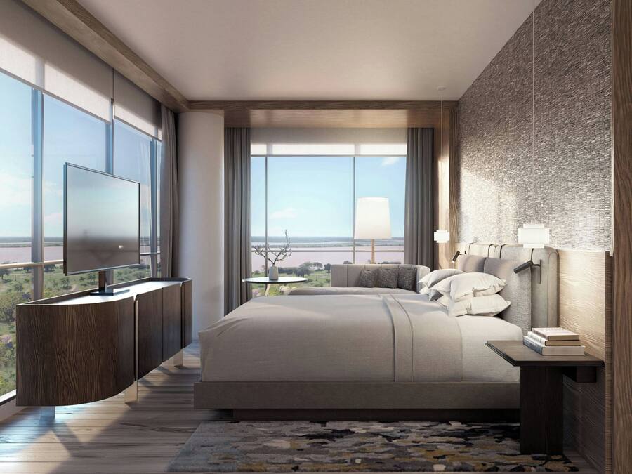 Un dormitorio moderno con una cama grande, un televisor y vistas al exterior.