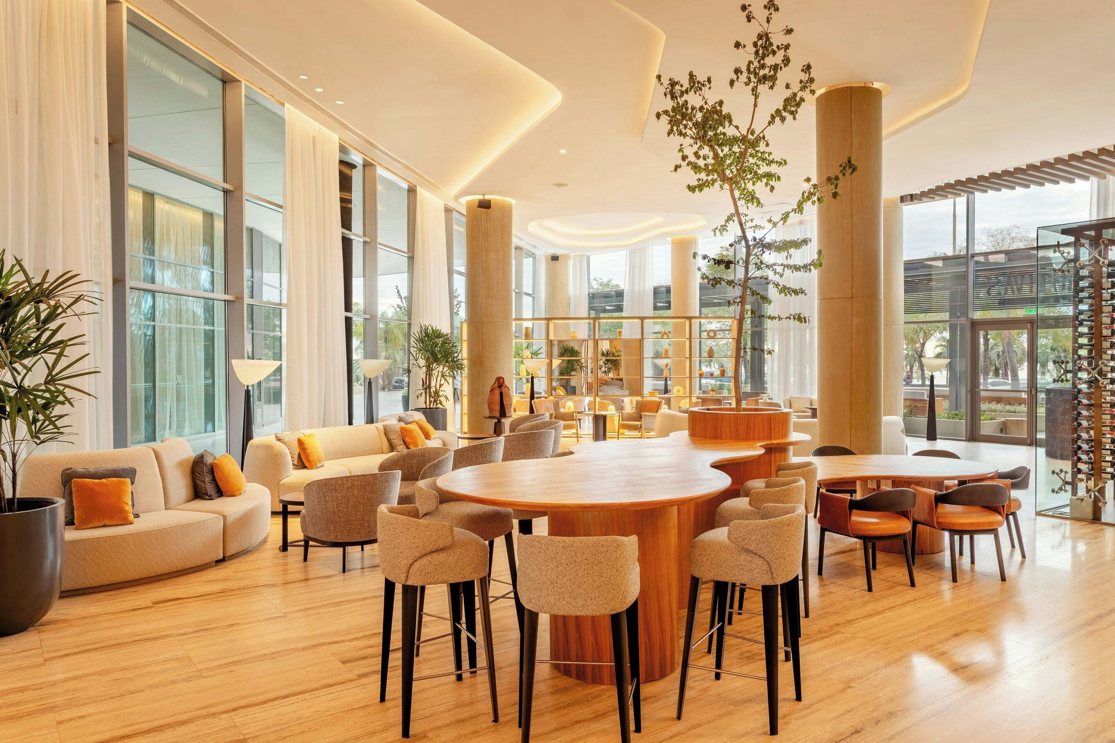 A spacious lounge area with a large round table, multiple seating options, and a sofa.