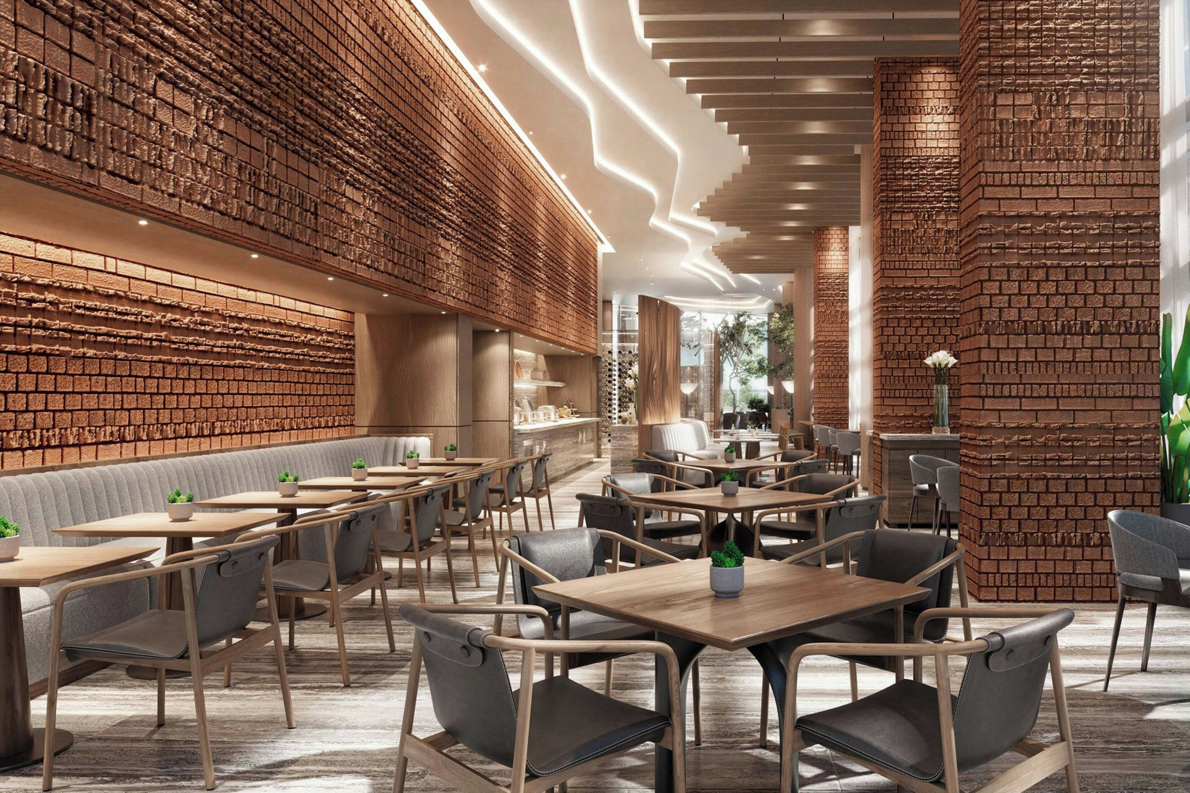 Ein modernes Restaurant mit Ziegelwänden, Holztischen und gepolsterten Sitzmöglichkeiten.
