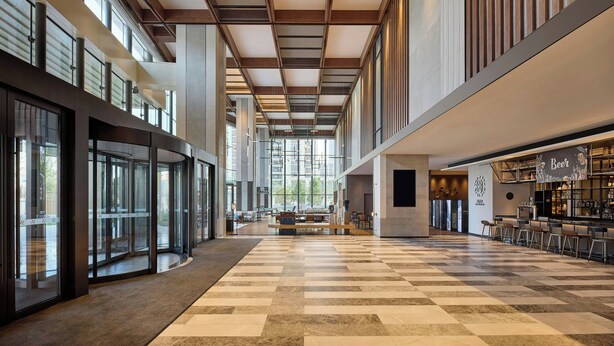 Un hall d’entrée spacieux, doté d’un sol à carreaux, de grandes fenêtres et d’un espace bar.