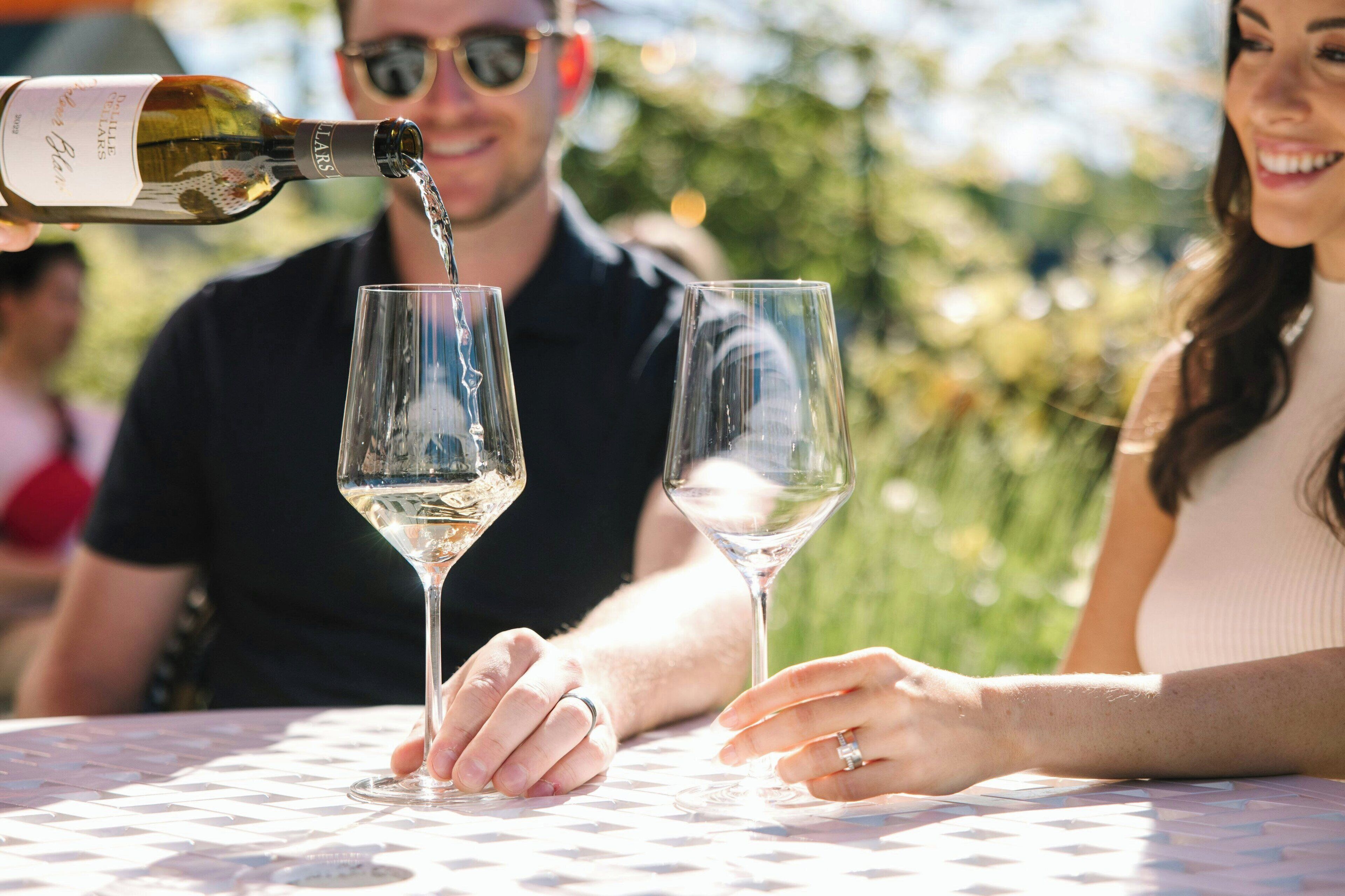 Une personne qui verse du vin dans un verre.