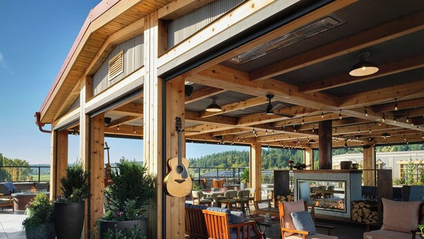 Un espace extérieur aménagé en terrasse, avec des meubles en bois, des plantes en pot et une cheminée.