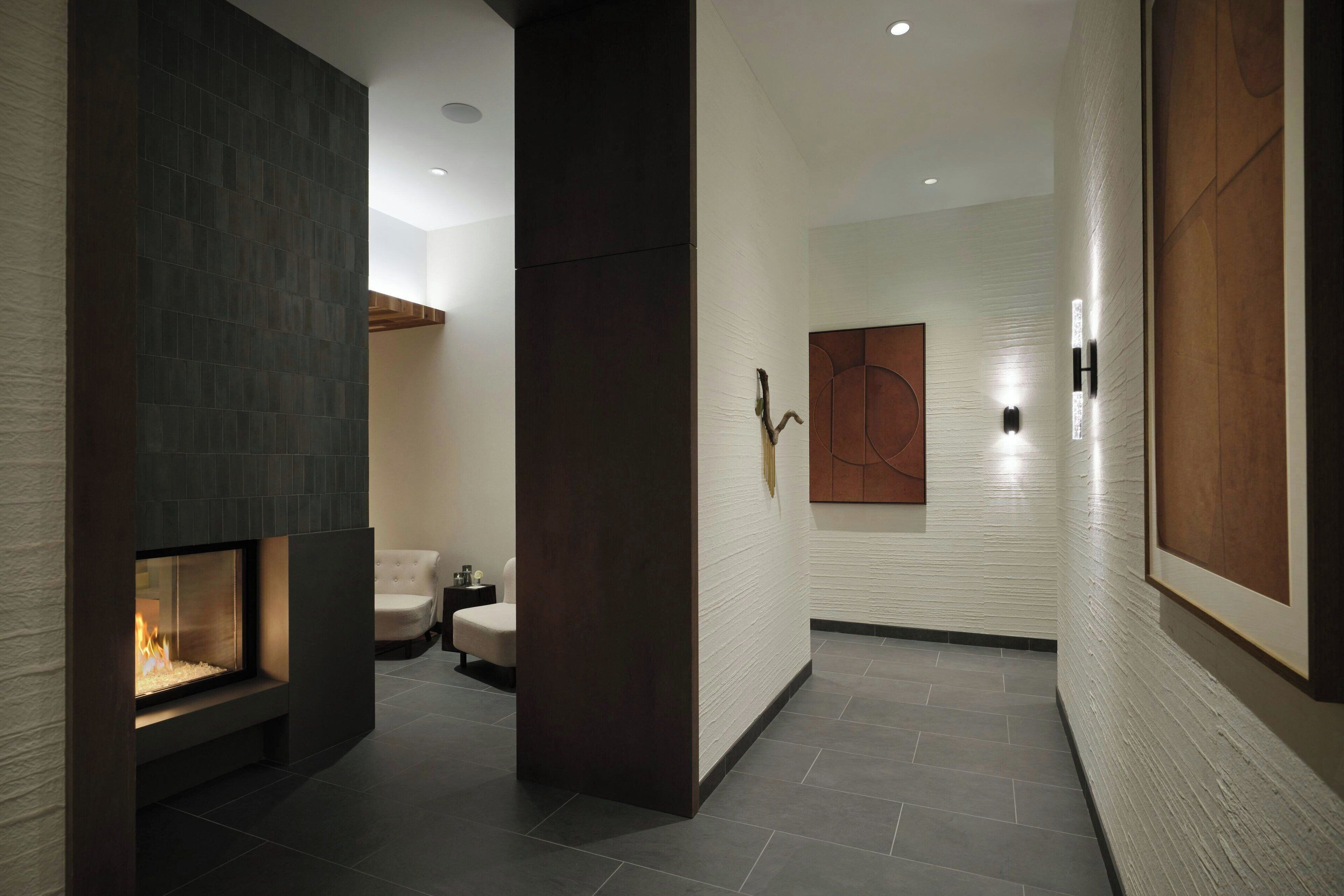 A modern interior with a fireplace, a white sofa, and a wooden accent wall.