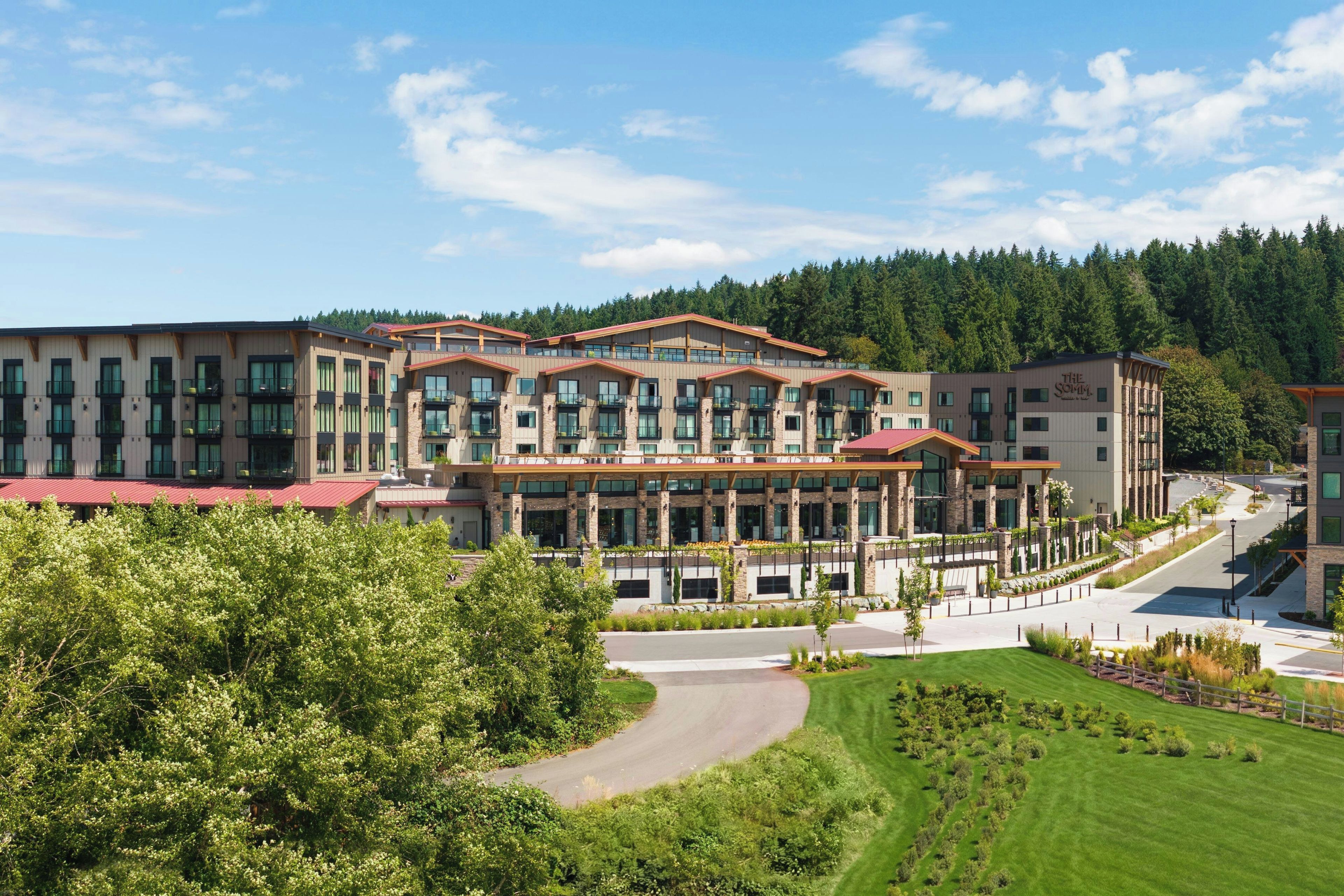 A multi-story hotel with a modern architectural design, featuring balconies and large windows.