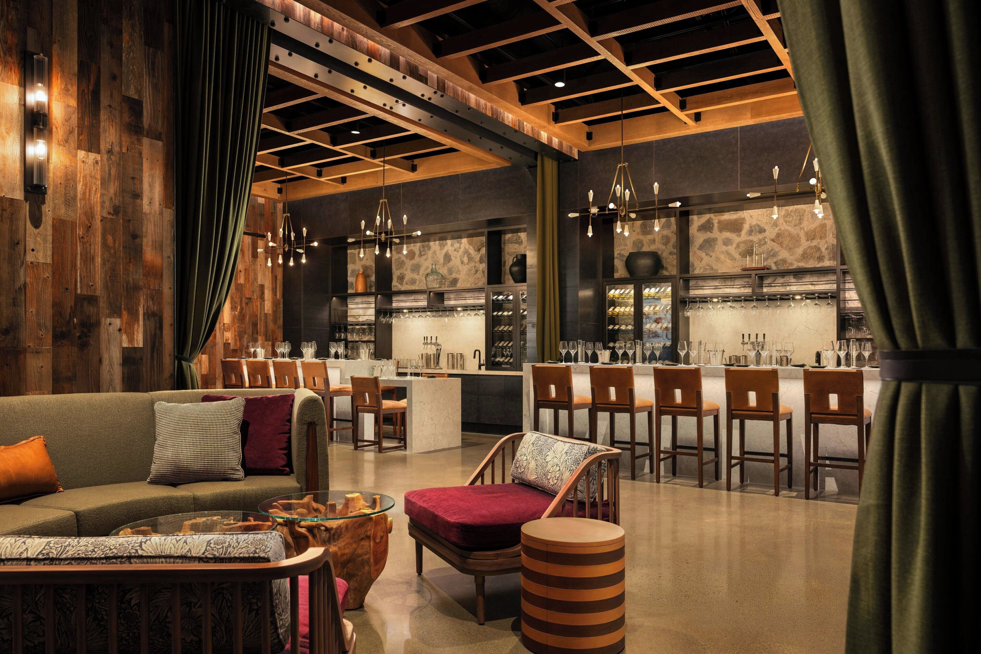 Un interior moderno con una zona de bar, asientos y una pared decorativa de madera.