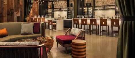 Un interior moderno con una zona de bar, asientos y una pared decorativa de madera.