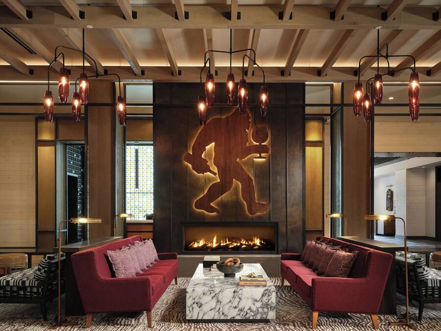 A modern living room with a fireplace, red sofas, and a marble coffee table.