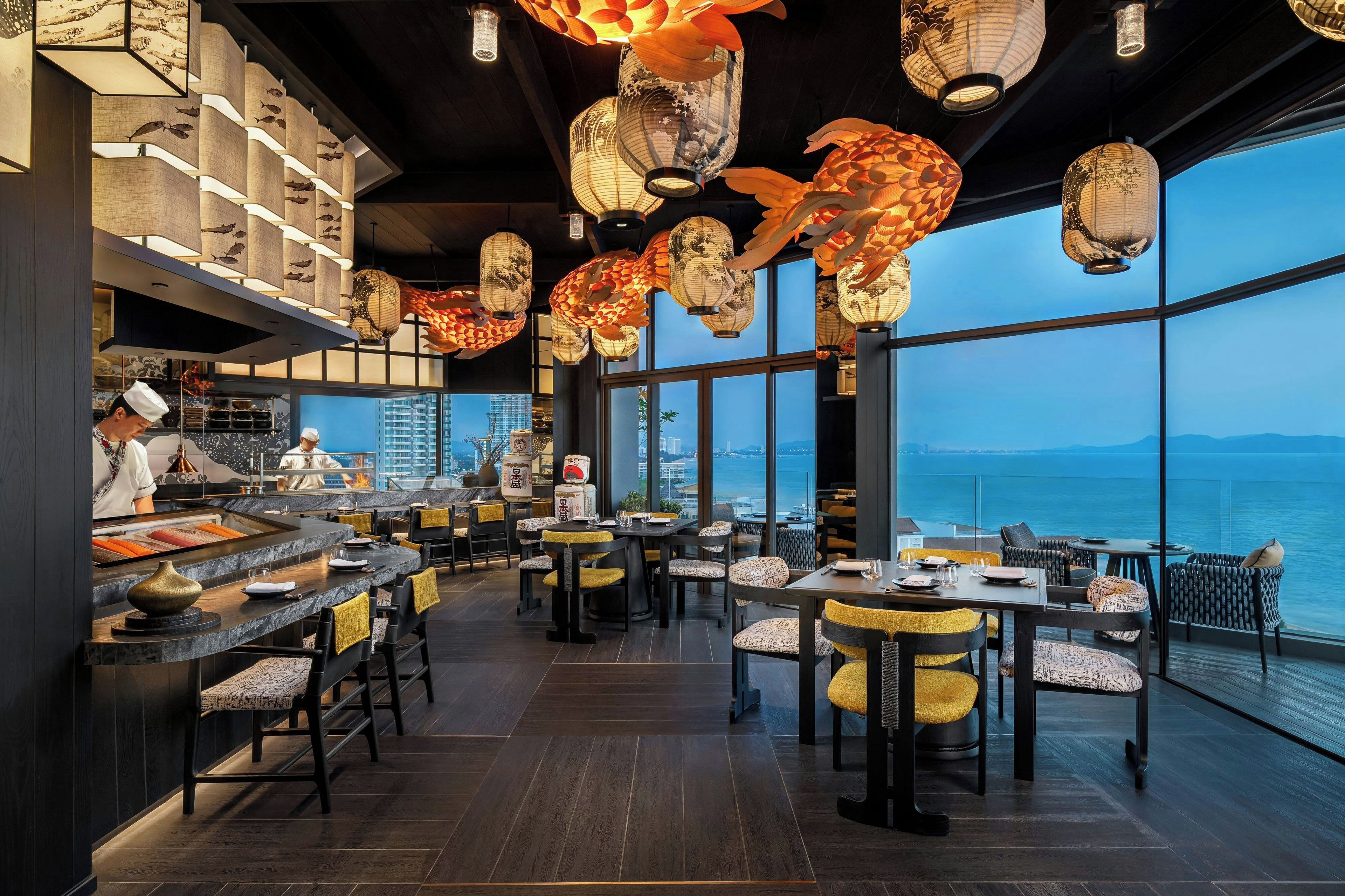 Un restaurante con vistas al mar, con faroles tradicionales y una decoración moderna.
