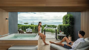 Ein moderner Poolbereich im Freien mit Whirlpool, Liegestühlen und Blick auf den Garten.