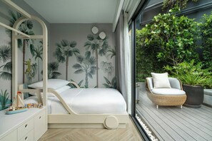 Ein Schlafzimmer mit einem Bett, einem Schminktisch, einem Sessel und einem großen Fenster mit Blick auf einen Garten.
