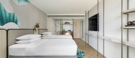 A modern hotel room with a large bed, a desk, a mirror, and a TV.