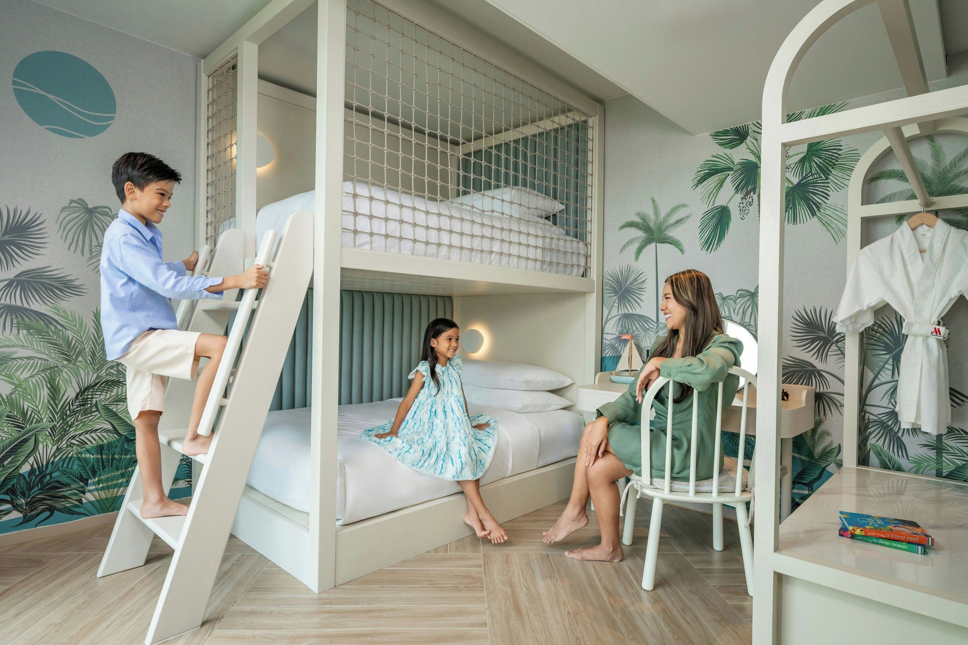 A room with a bunk bed, a ladder, and a chair.