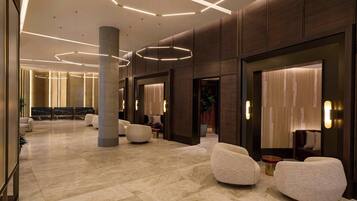 A spacious lobby with a marble floor, modern seating, and ambient lighting.