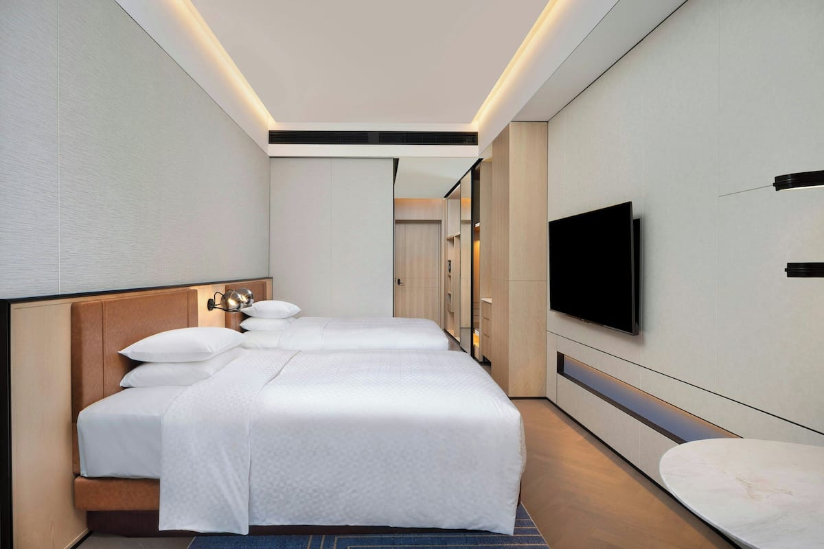 Een moderne hotelkamer met een groot bed, een flatscreen televisie aan de muur en een zithoekje.