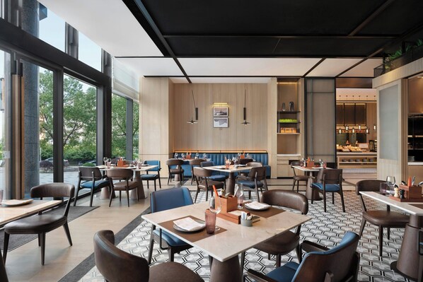 A modern restaurant with a mix of booths and tables, large windows offering a view of the outdoors, and a clean, contemporary interior design. - Four Points By Sheraton Suzhou Gusu (Suzhou)