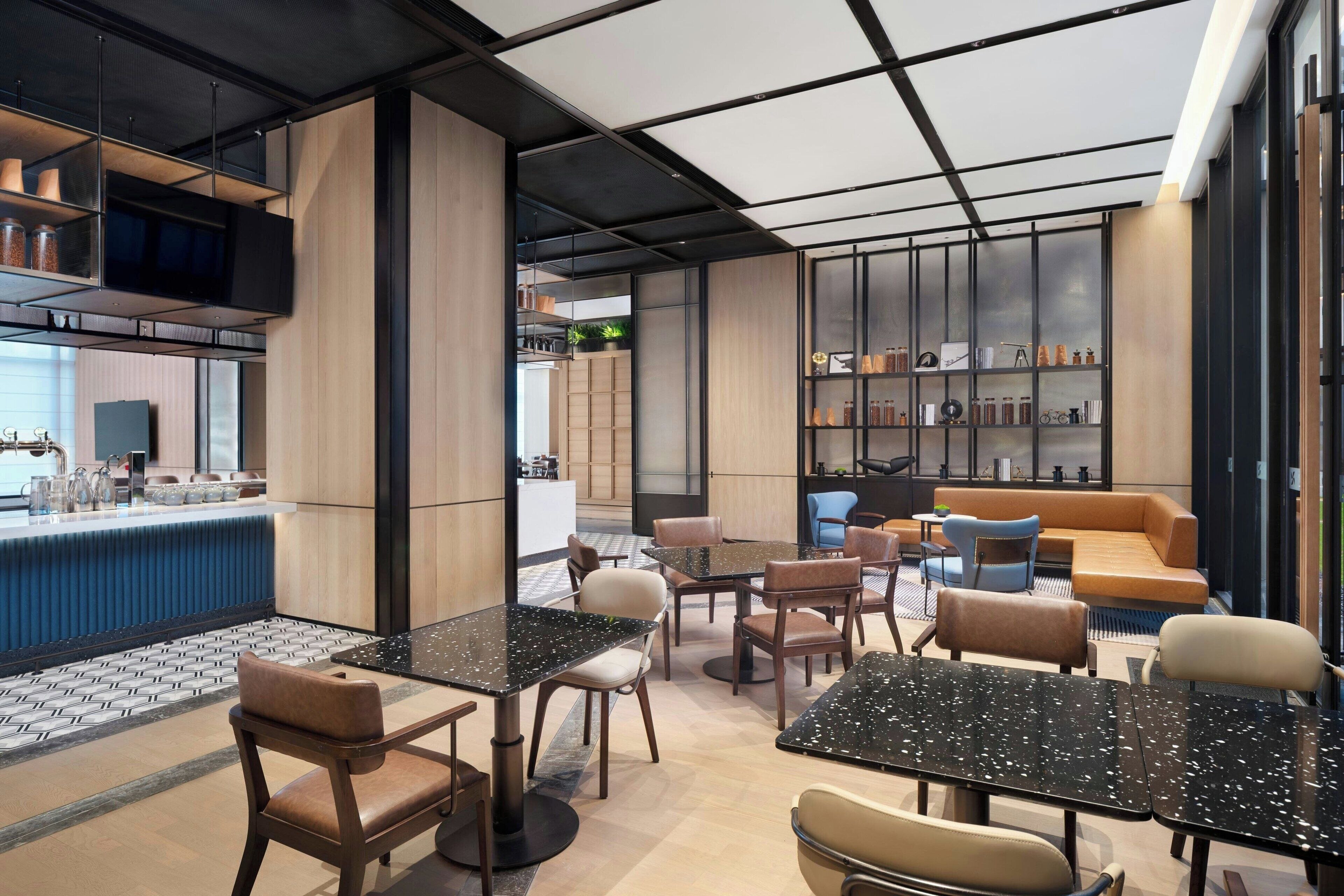 A modern interior with seating areas, a bar, and shelves with items.