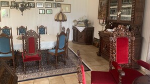 A dining room with a table and chairs, a chandelier, a cabinet with glassware, and framed pictures on the wall. - Villa in the middle of Haselünnne (Haselünne)