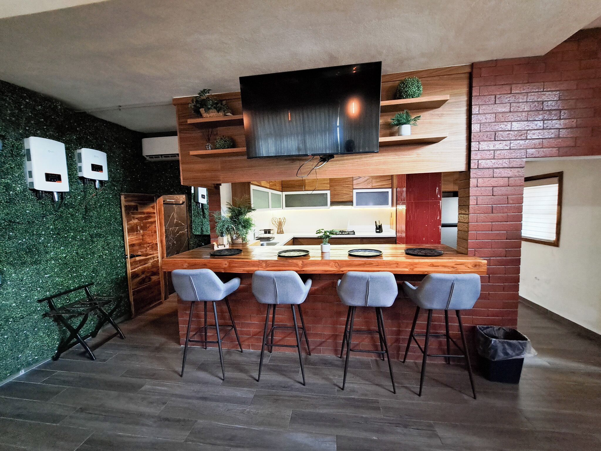 Una cocina moderna con una isla de madera, taburetes de bar y un televisor montado sobre la isla.