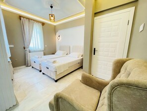 Ein Hotelzimmer mit zwei Betten, einer Couch, einer Tür und einer Deckenleuchte.