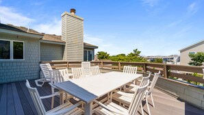 A deck with a white table and chairs, surrounded by a wooden deck and a railing. - 1300 - Sea Chest - Corolla Light | Beach Access & Community Amenities (Corolla)