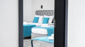 A hotel room with two beds, each with a blue bedspread and white pillows. - Hotel Mondo  (Budva)