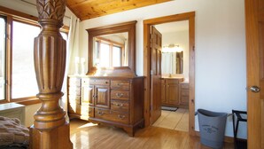 A spacious room with a large wooden dresser, a mirror, and a laundry room.