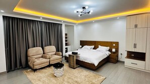 A modern bedroom with a bed, a chair, a bedside table, and a wardrobe. - Addis Home & Comfort - Sarbet - Addis Ababa (Addis Ababa)
