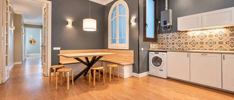 A modern kitchen with a central island, built-in appliances, and a patterned backsplash.