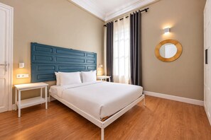 A hotel room with a bed, bedside tables, a wall-mounted mirror, and a window with curtains. - Sweett | Sepulveda 2A (Barcelona)