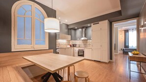 Una cocina moderna con comedor, un amplio ventanal y vistas al salón.