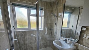 Une salle de bain moderne avec une douche à parois de verre, un lavabo et des toilettes.