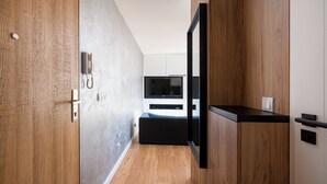 Een moderne slaapkamer met een houten vloer, een bed, een televisie en een kledingkast.