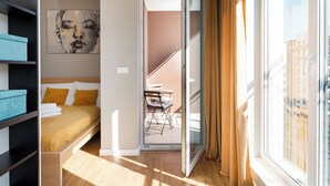 Een moderne slaapkamer met een bed, uitzicht op een balkon en een stadsgezicht.