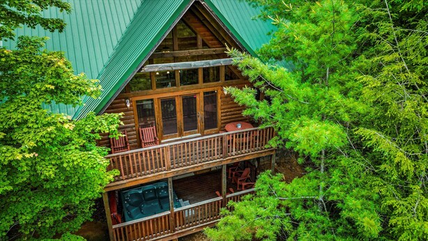 A log cabin with a balcony and a large window.