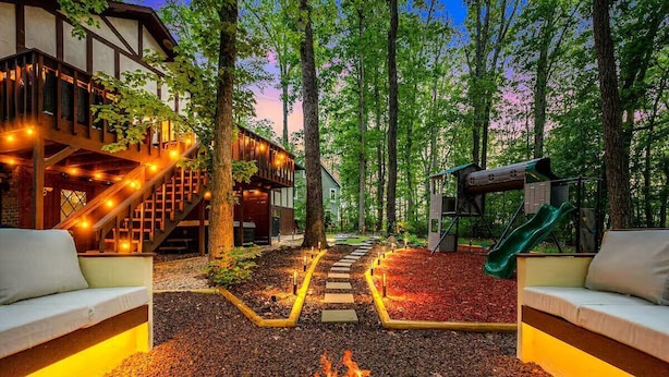 Ein gemütlicher Außenbereich mit Feuerstelle, Holzterrasse und einer Rutsche.