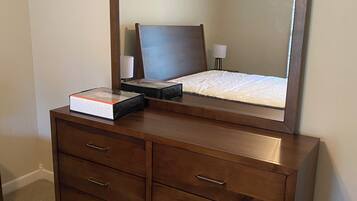 Een houten dressoir met lades en een spiegel erboven.