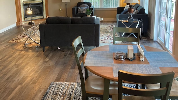 A spacious living room with a fireplace, a dining area with a table and chairs, and a large window providing natural light. - Charming 2-bdrm house with AC, WiFi in Cherokee Village with amazing river views (Cherokee Village)