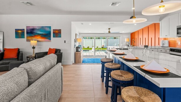 A modern living room with a sofa, a coffee table, and a painting on the wall. - Fancy That: Pool, Putting Green, 1.5 Blocks to Beach by Anna Maria Life Vacation Rentals (Holmes Beach)