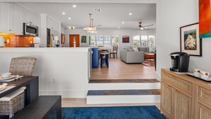 A modern kitchen with white cabinetry, a built-in microwave, and a stainless steel oven. - Fancy That: Pool, Putting Green, 1.5 Blocks to Beach by Anna Maria Life Vacation Rentals (Holmes Beach)