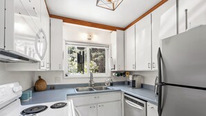 A modern kitchen with white cabinets, a stainless steel refrigerator, a built-in dishwasher, and a gas stove. - Charming 3-bedroom cabin with AC, WiFi in serene Idyllwild-Pine Cove (Idyllwild-Pine Cove)