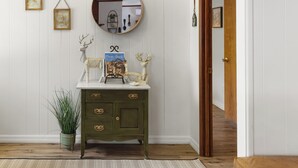 A wooden dresser with a mirror above it, a framed picture, and a plant beside it. - Charming 3-bedroom cabin with AC, WiFi in serene Idyllwild-Pine Cove (Idyllwild-Pine Cove)