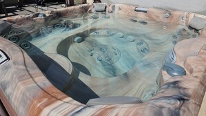 Een jacuzzi met meerdere jets, een ingebouwde verwarming en een bedieningspaneel.